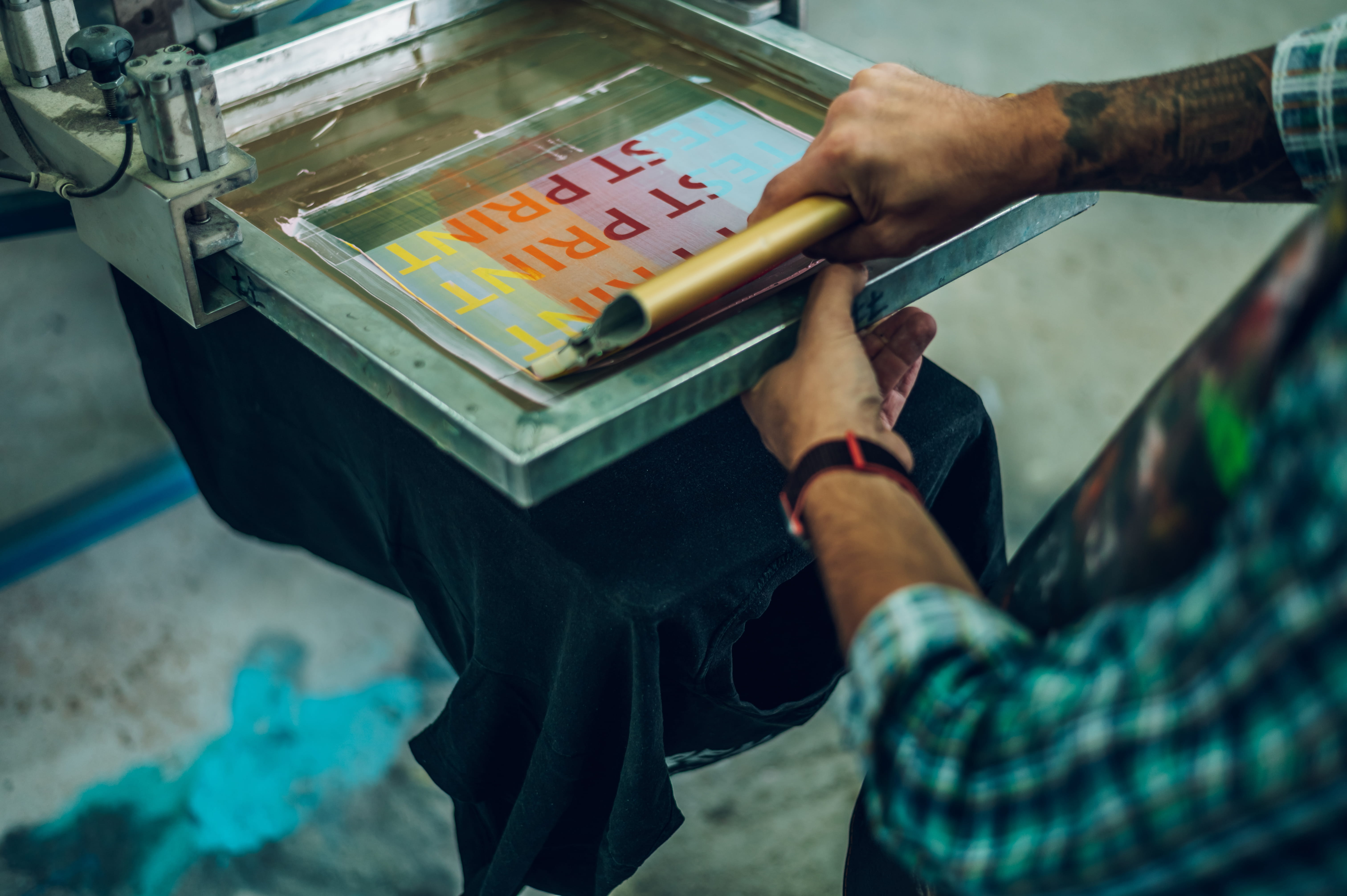 man screen printing a shirt at workshop utc